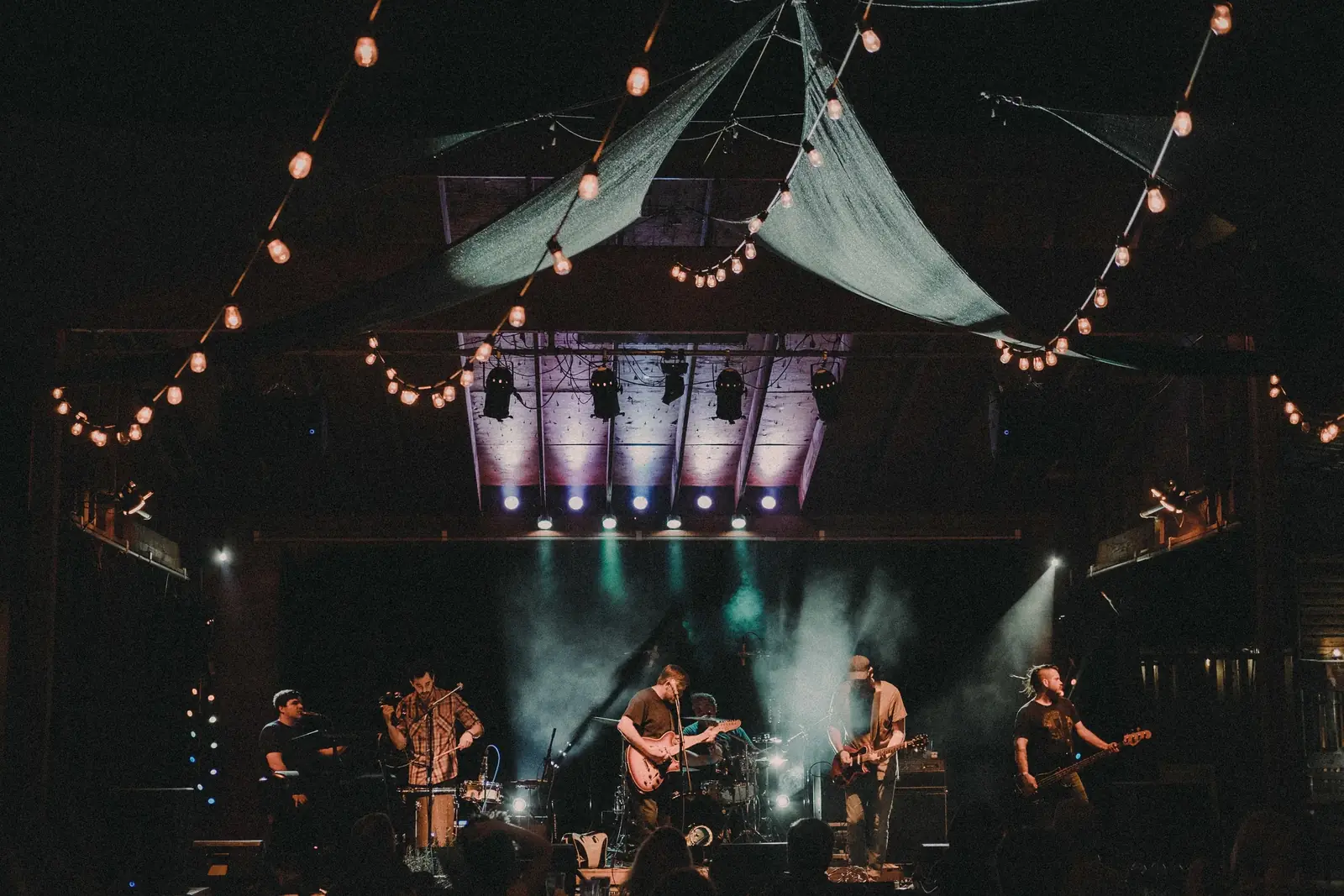 A band playing live on the Harvest House stage